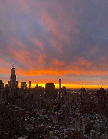 Panoramic view of a city skyline at sunset with a vibrant sky.
