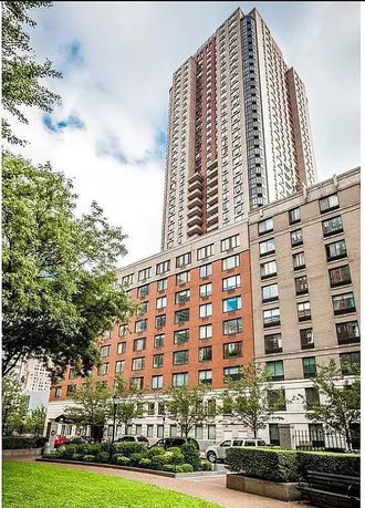 Front view of a tall multi-story building with a mix of brick and concrete facade.