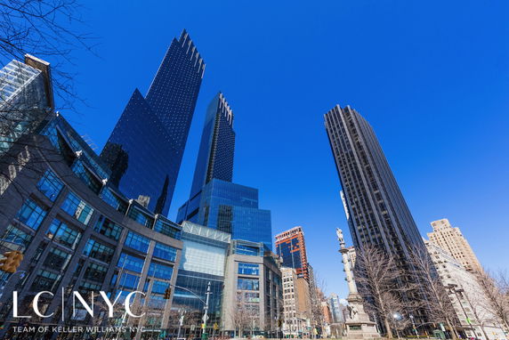 Front view of tall skyscrapers and modern buildings in a cityscape.