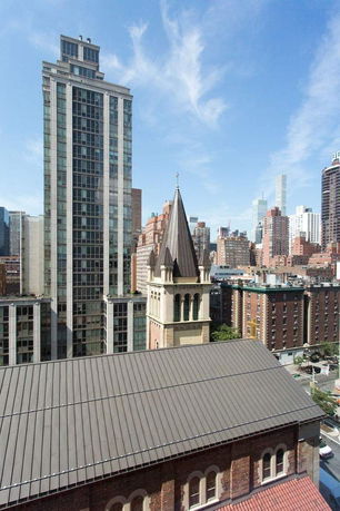 View of a cityscape with modern and historical buildings under a blue sky.
