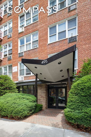 Front view of a multi-story brick building with an entrance canopy.