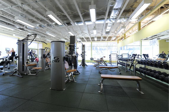 View of a gym area with various exercise machines and free weights.