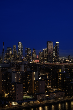 Nighttime panoramic view of a city skyline with illuminated skyscrapers.