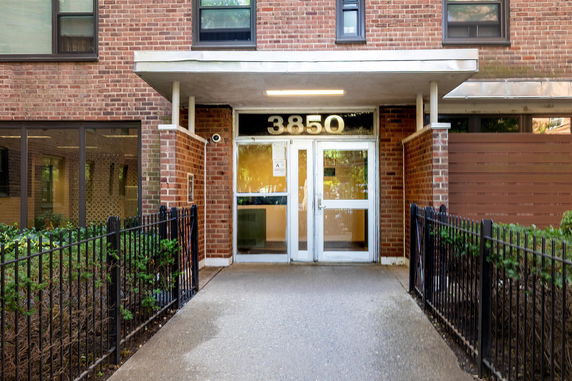 Front view of a brick apartment building with glass doors.