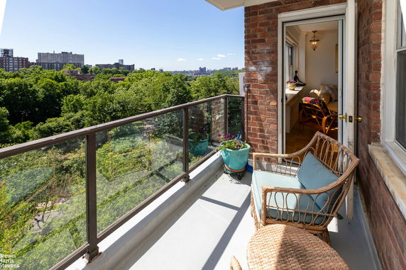 Balcony with a view of surrounding buildings and greenery