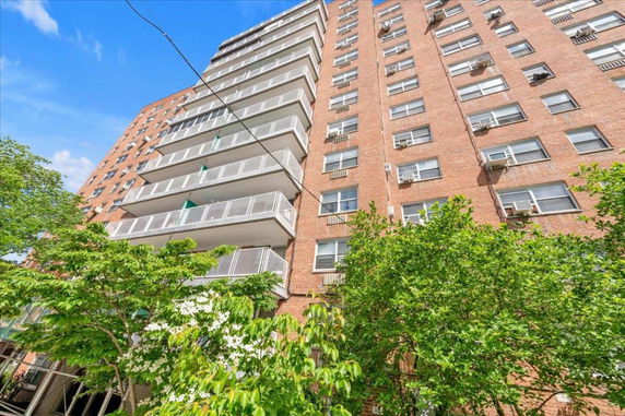 Front view of a multi-story apartment building with balconies.