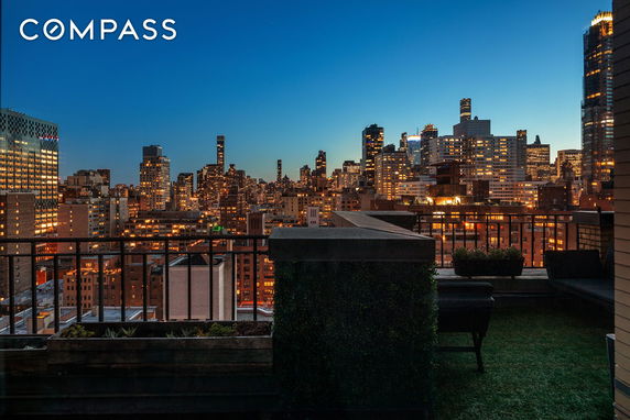 Panoramic view of city skyline from a rooftop at dusk.