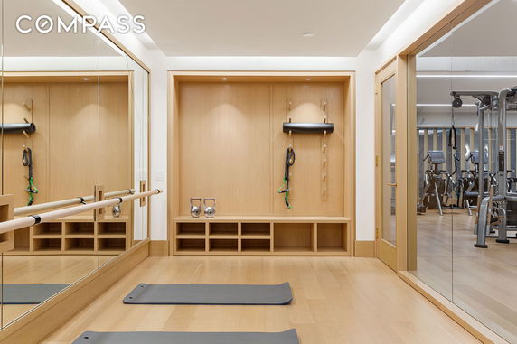 Indoor gym area with workout equipment and mirrored walls