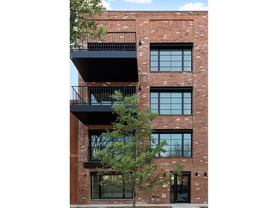 Front view of a multi-story brick building with balconies.