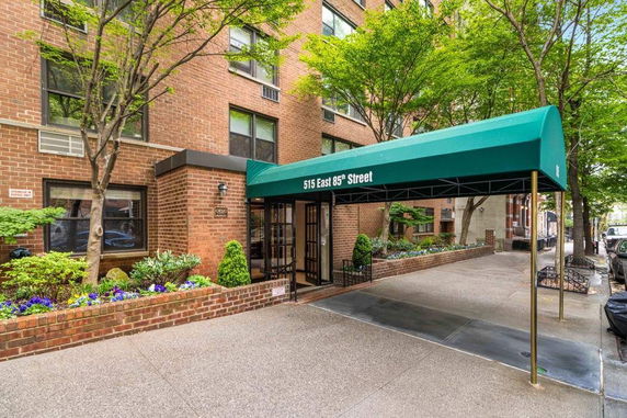 Front view of a multi-story brick building with a green canopy entrance.