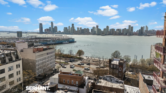 Panoramic view of a cityscape with buildings overlooking a large body of water.