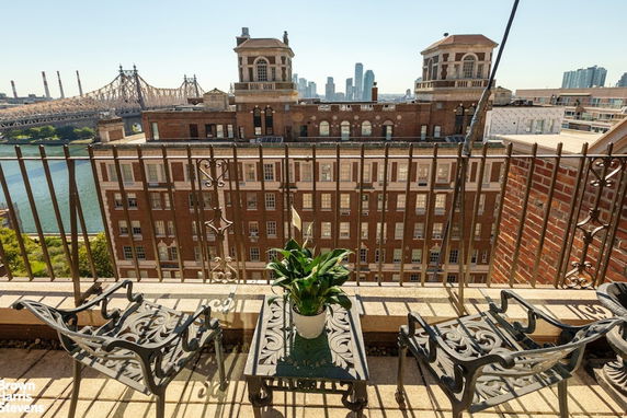 Panoramic view from a balcony overlooking a bridge and buildings.