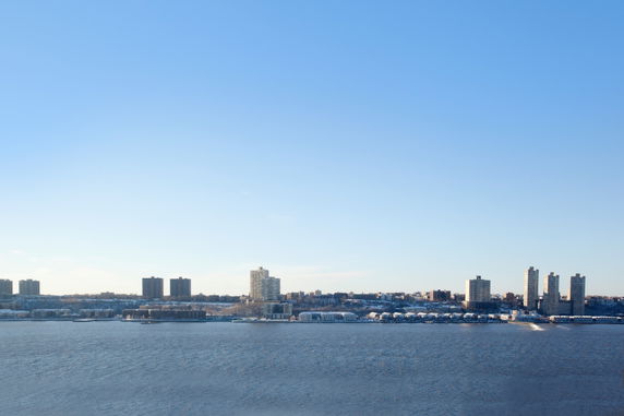 View of buildings along a waterfront with a clear blue sky.