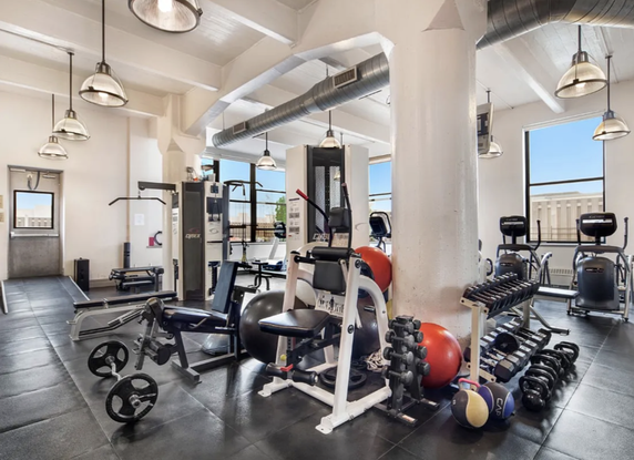 Interior view of a gym with various exercise equipment and weights.