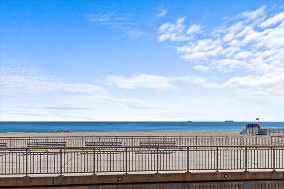 Wide angle view of the beach and ocean with a clear sky.