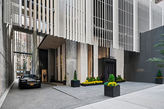 Front view of a modern building with decorative vertical slats and a grand entrance.