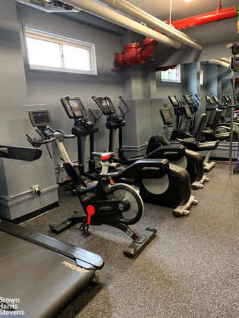 Indoor gym area with exercise bikes and treadmills.