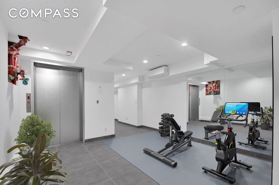 Indoor gym area with exercise equipment and elevator.
