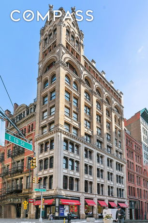 Front view of a multi-story historic building with arched windows and detailed architectural elements.