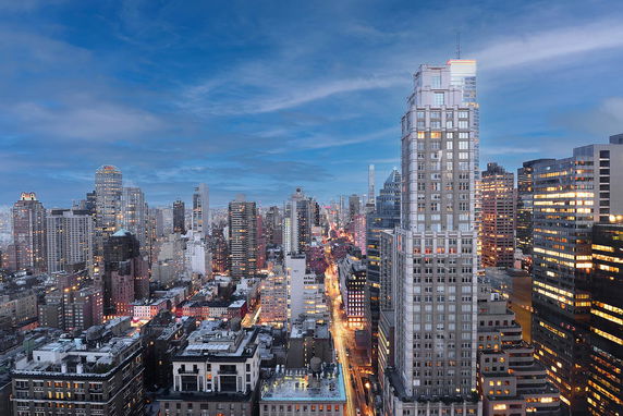 Panoramic view of a city skyline with multiple skyscrapers at dusk.