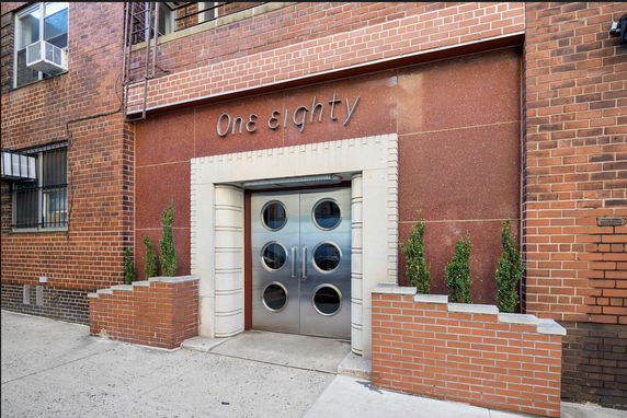 Front view of a building entrance with a decorative double door and brick exterior.