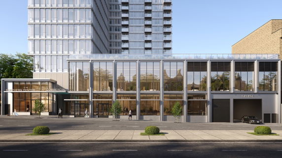 Front view of a modern multi-story commercial building with glass façade and retail spaces.