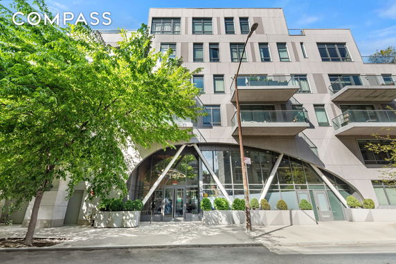 Front view of a modern multi-story building with large windows and balconies.