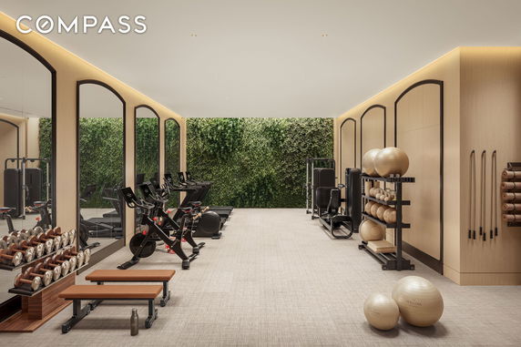 Indoor gym area with exercise equipment and mirrored walls.