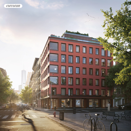 Front view of a multi-story red brick building on a street corner.