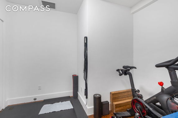 Indoor exercise area with stationary bike and fitness equipment.