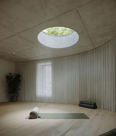 Room with circular skylight and yoga mats on the floor.