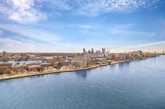 Wide angle view of a cityscape with a river and buildings.