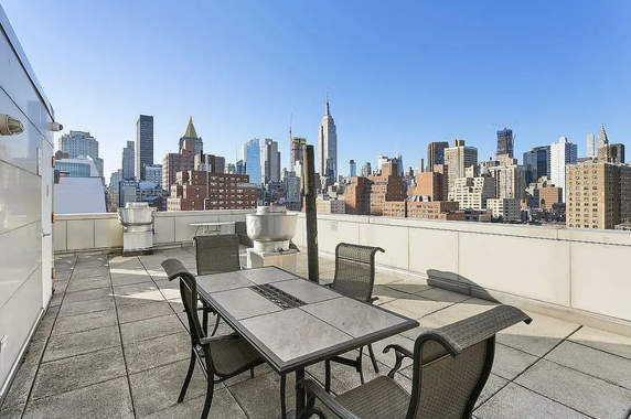 Rooftop terrace with seating area and city skyline view.