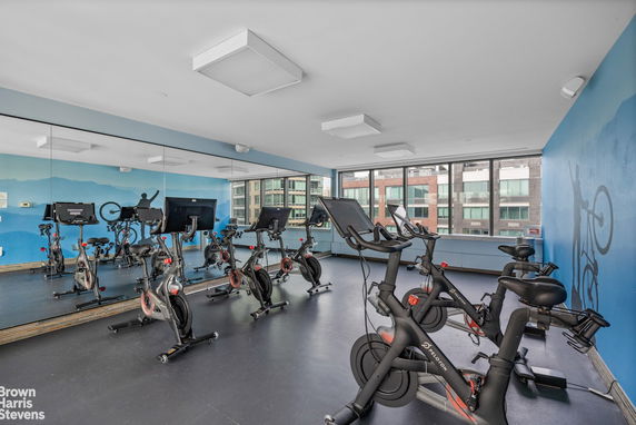 Indoor gym area with stationary exercise bikes and large mirrors.