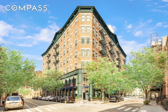 Front view of a multi-story brick building with fire escapes.