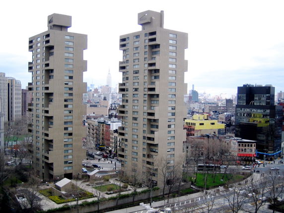 View of two tall apartment buildings with a cityscape in the background.