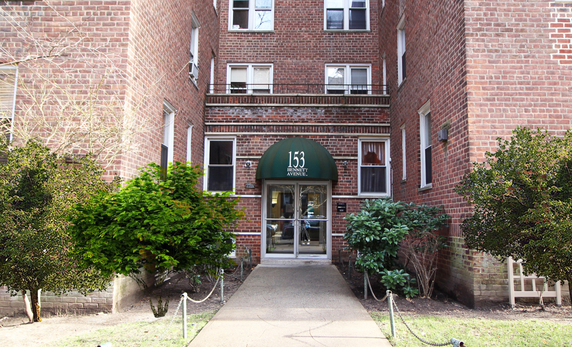 Front view of a multi-story brick building with an entrance canopy.