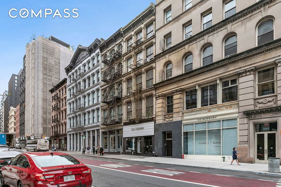 Street view of multi-story buildings with fire escapes.