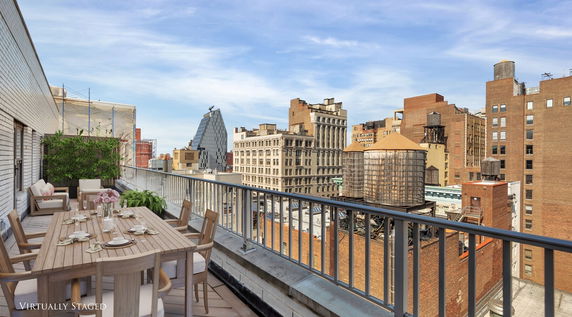 Rooftop view with outdoor seating and distant cityscape.