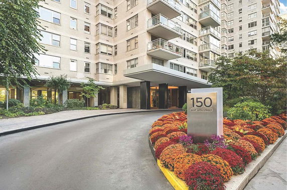Front view of a multi-story building with a curved driveway and landscaped entrance.
