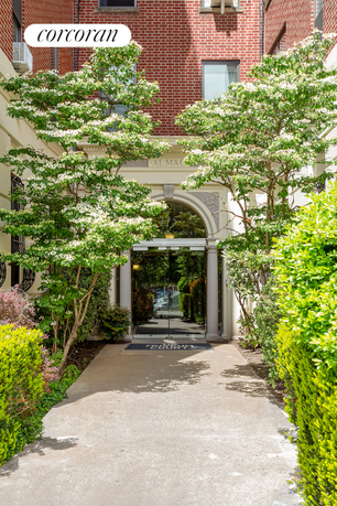 Front entrance of a brick building with glass doors and decorative archway.