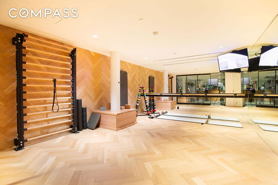 Interior view of a fitness room with exercise equipment and a mirrored wall.