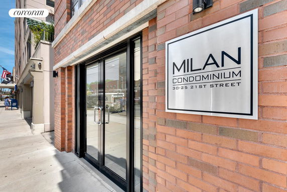 Front view of a multi-story condominium building with brick exterior and glass entrance doors.