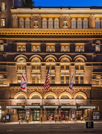 Front view of a multi-story historic building with arched windows and ornate architectural details.
