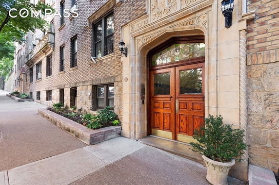 Front view of a multi-story brick building with ornate wooden doors.