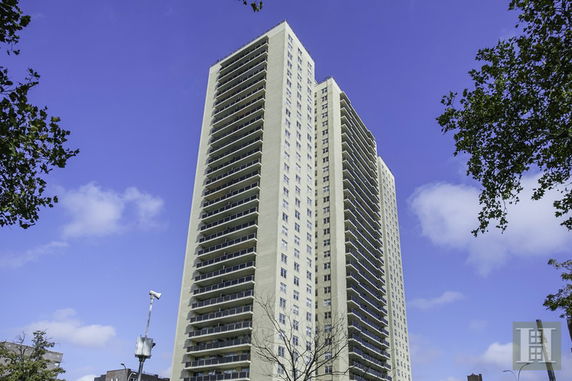 Front view of a tall apartment building with multiple balconies.