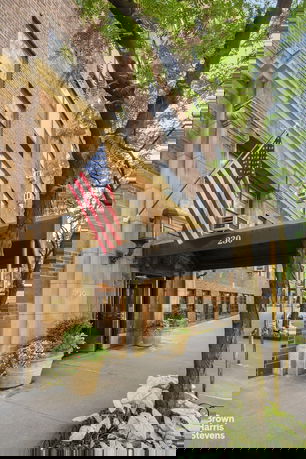 Front view of a brick building with an overhanging structure displaying the number 230.