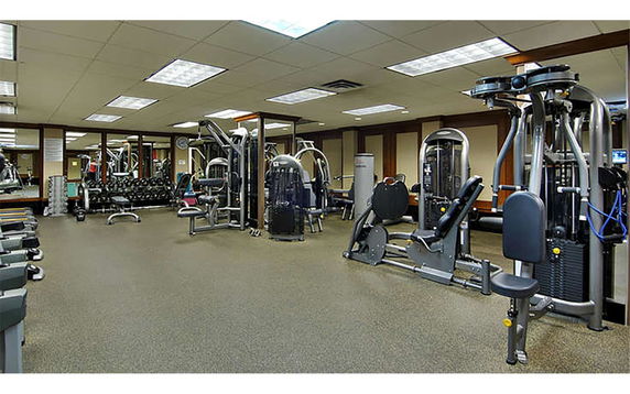 Room equipped with various fitness machines.
