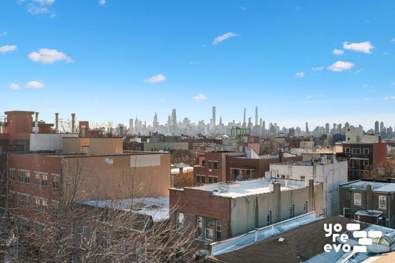 Panoramic view of city rooftops with a skyline in the background.