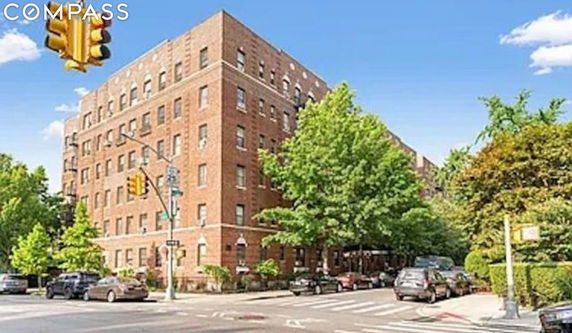 Corner view of a multi-story brick building on a city street.